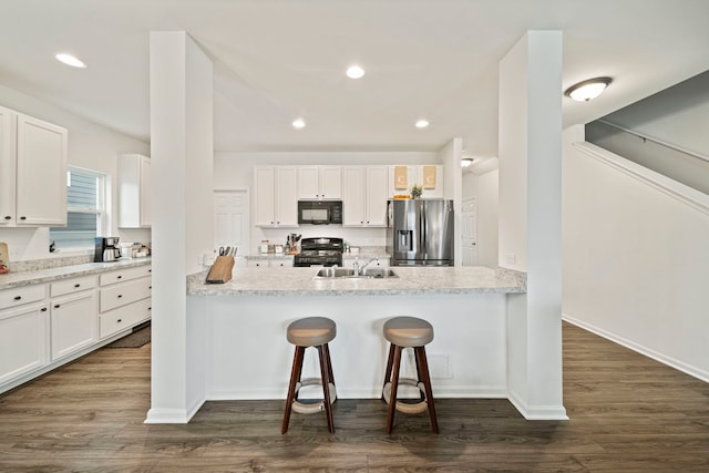 3778 Westbury Ct, Elgin, IL 60124 - kitchen featuring black appliances, white cabinetry, a breakfast bar, dark wood-style floors, and recessed lighting