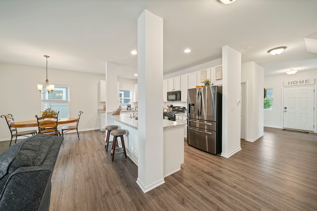 3778 Westbury Ct, Elgin, IL 60124 - kitchen with black appliances, white cabinetry, dark wood-type flooring, a breakfast bar, and pendant lighting