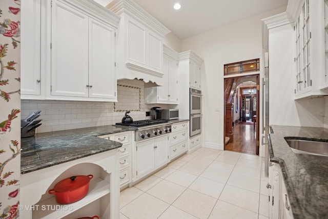 2124 N Cleveland Ave, Chicago, IL 60614 - kitchen featuring appliances with stainless steel finishes, white cabinetry, light tile patterned flooring, tasteful backsplash, and dark stone counters