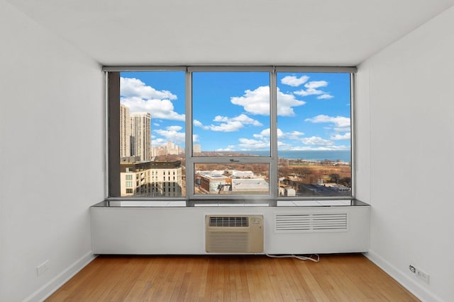 70 W Burton Pl Unit 1801, Chicago, IL 60610 - spare room featuring wood-type flooring, an AC wall unit, and healthy amount of natural light