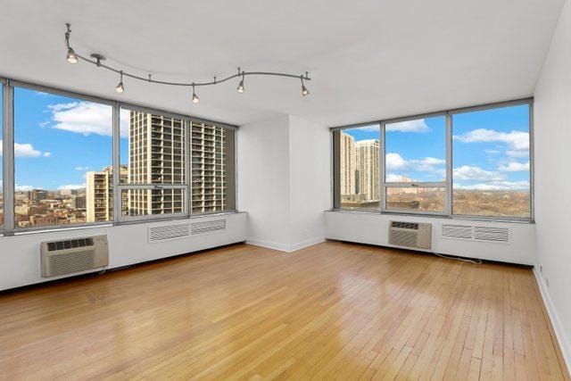 70 W Burton Pl Unit 1801, Chicago, IL 60610 - spare room with hardwood / wood-style floors, healthy amount of natural light, a wall unit AC, and a wall mounted air conditioner