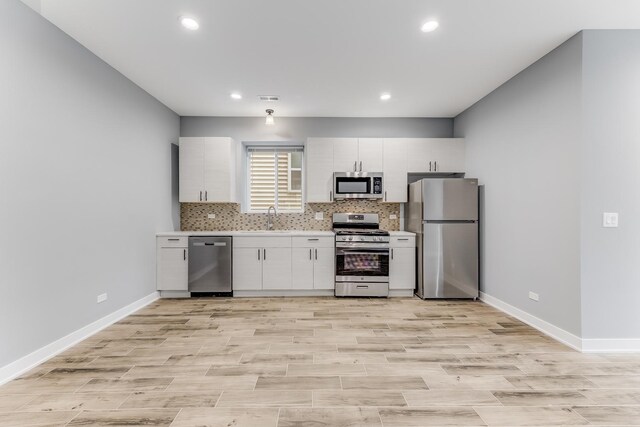 2708 W Jackson Blvd, Chicago, IL 60612 - kitchen with appliances with stainless steel finishes, light countertops, tasteful backsplash, white cabinetry, and recessed lighting