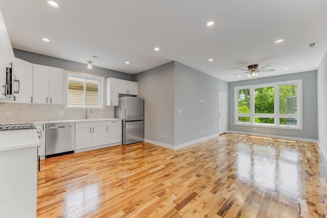 2708 W Jackson Blvd, Chicago, IL 60612 - kitchen with appliances with stainless steel finishes, light countertops, light wood-style flooring, tasteful backsplash, and recessed lighting