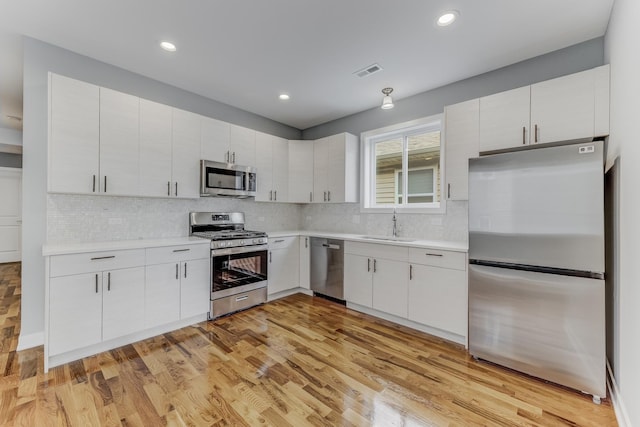 2708 W Jackson Blvd, Chicago, IL 60612 - kitchen with stainless steel appliances, light countertops, decorative backsplash, white cabinetry, and recessed lighting