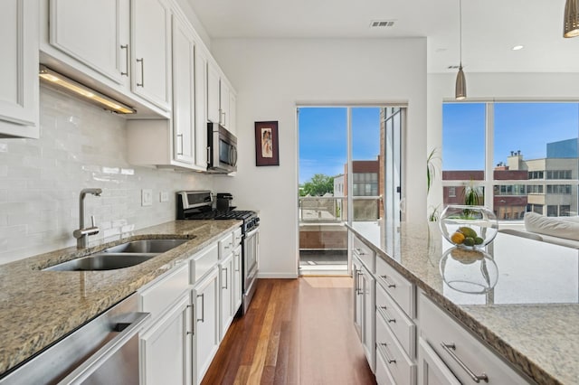 1719 N Western Ave Unit 4, Chicago, IL 60647 - kitchen with stainless steel appliances, decorative backsplash, plenty of natural light, white cabinets, and recessed lighting