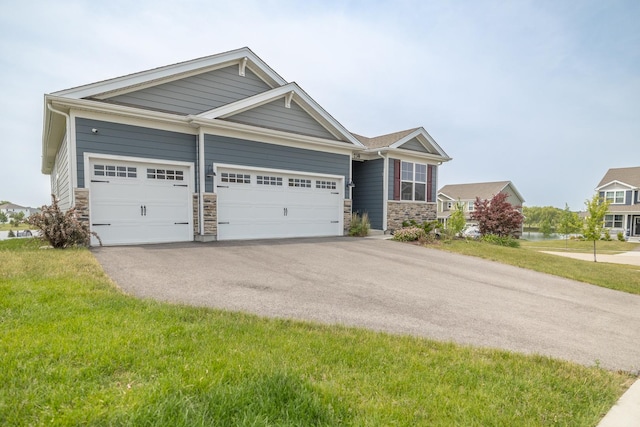 738 Kentshire Cir, Elgin, IL 60124 - view of front of house with stone siding, asphalt driveway, an attached garage, and a front lawn