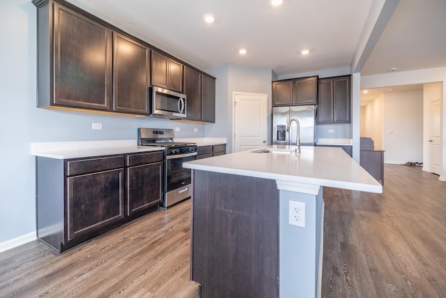 738 Kentshire Cir, Elgin, IL 60124 - kitchen featuring appliances with stainless steel finishes, light wood-style flooring, dark brown cabinetry, an island with sink, and light countertops