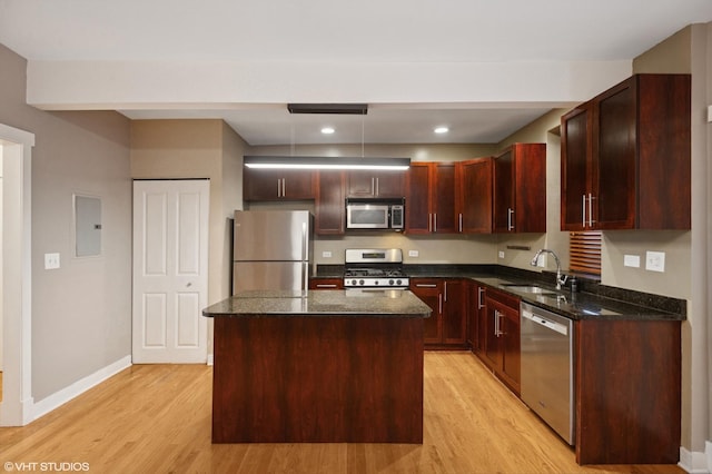 2305 N Kimball Ave Unit 1, Chicago, IL 60647 - kitchen featuring appliances with stainless steel finishes, light wood-style flooring, a kitchen island, dark stone counters, and recessed lighting