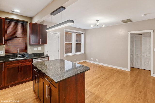 2305 N Kimball Ave Unit 1, Chicago, IL 60647 - kitchen with light wood-style floors, a kitchen island, dark stone countertops, and recessed lighting