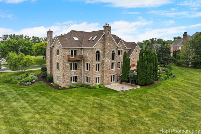 39 Forest Ln, South Barrington, IL 60010 - rear view of house featuring a balcony, a patio, a chimney, and a lawn