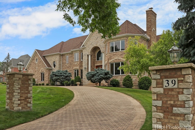 39 Forest Ln, South Barrington, IL 60010 - tudor-style house with a front yard, brick siding, a chimney, and curved driveway