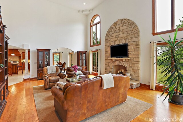 39 Forest Ln, South Barrington, IL 60010 - living area with a towering ceiling, ornate columns, arched walkways, light wood-style floors, and a stone fireplace