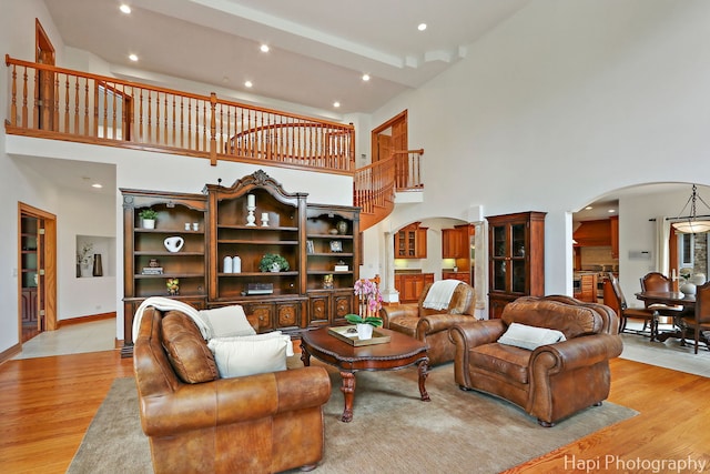 39 Forest Ln, South Barrington, IL 60010 - living room featuring arched walkways, a towering ceiling, light wood-style floors, recessed lighting, and beam ceiling