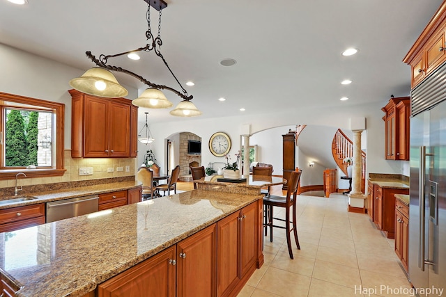 39 Forest Ln, South Barrington, IL 60010 - kitchen with appliances with stainless steel finishes, arched walkways, light stone counters, recessed lighting, and light tile patterned floors