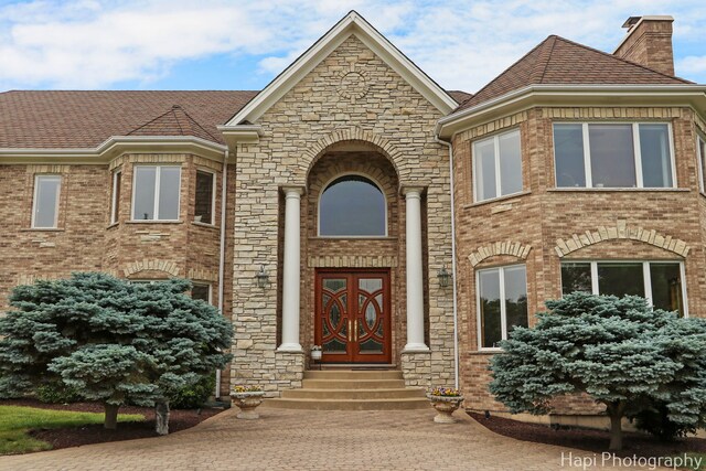 39 Forest Ln, South Barrington, IL 60010 - doorway to property featuring brick siding, a chimney, stone siding, and roof with shingles