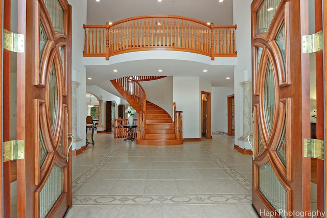 39 Forest Ln, South Barrington, IL 60010 - foyer with a towering ceiling, light tile patterned floors, stairs, inlaid floor details, and ornate columns