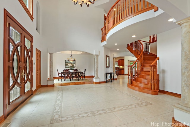 39 Forest Ln, South Barrington, IL 60010 - tiled entryway with ornate columns, a towering ceiling, arched walkways, stairs, and a chandelier