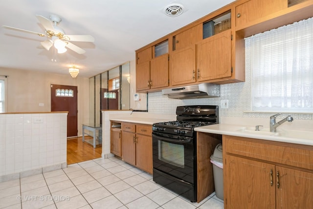 4912 W 32nd St, Cicero, IL 60804 - kitchen featuring black gas range, under cabinet range hood, a ceiling fan, light countertops, and light tile patterned floors