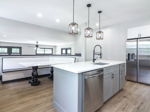 246 S Oak St, Itasca, IL 60143 - kitchen featuring appliances with stainless steel finishes, light wood finished floors, gray cabinetry, a center island with sink, and a ceiling fan