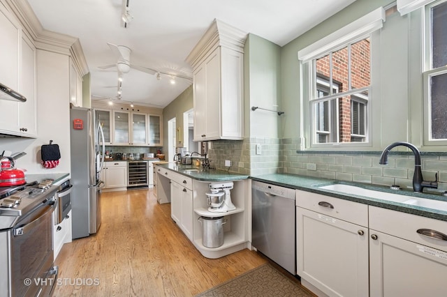 2440 N Lakeview Ave Unit 14E, Chicago, IL 60614 - kitchen featuring stainless steel appliances, beverage cooler, rail lighting, light wood-style flooring, and white cabinets