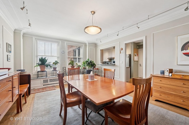 2440 N Lakeview Ave Unit 14E, Chicago, IL 60614 - dining area with crown molding, light wood-style floors, rail lighting, and radiator