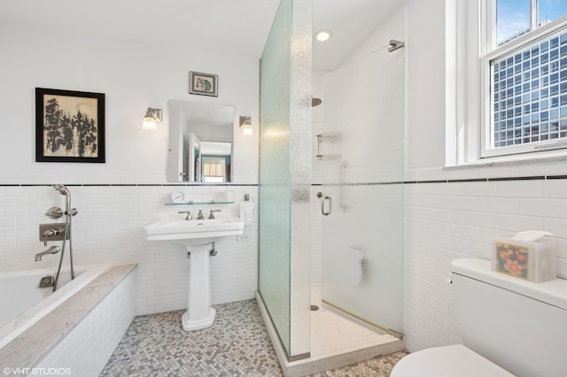 2440 N Lakeview Ave Unit 14E, Chicago, IL 60614 - bathroom with tile walls, a bath, a shower stall, a wainscoted wall, and tile patterned flooring