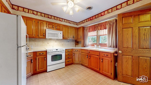 74 Wilmette Dr, Oswego, IL 60543 - kitchen featuring white appliances, brown cabinets, light countertops, ceiling fan, and tasteful backsplash