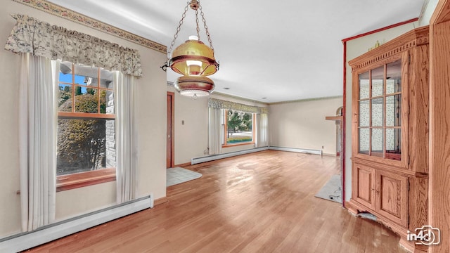74 Wilmette Dr, Oswego, IL 60543 - unfurnished dining area with baseboard heating, wood finished floors, and ornamental molding