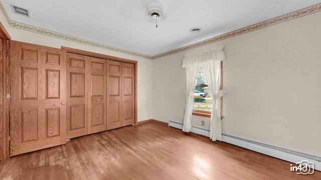 74 Wilmette Dr, Oswego, IL 60543 - unfurnished bedroom with light wood-type flooring, a baseboard radiator, and a closet