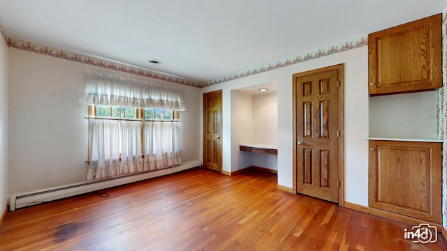 74 Wilmette Dr, Oswego, IL 60543 - unfurnished bedroom featuring a baseboard heating unit, built in desk, and light wood finished floors