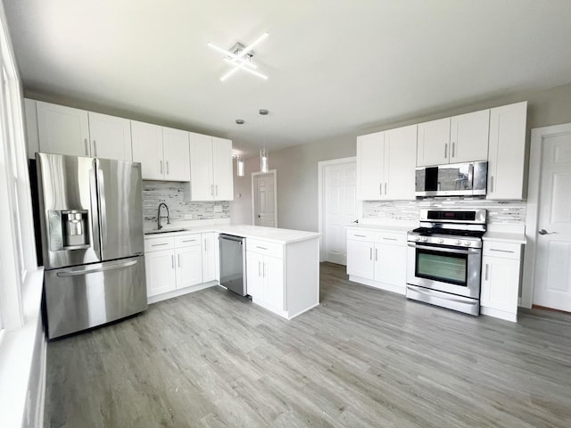1509 Saint Charles Rd, Maywood, IL 60153 - kitchen featuring stainless steel appliances, backsplash, light countertops, light wood finished floors, and a peninsula