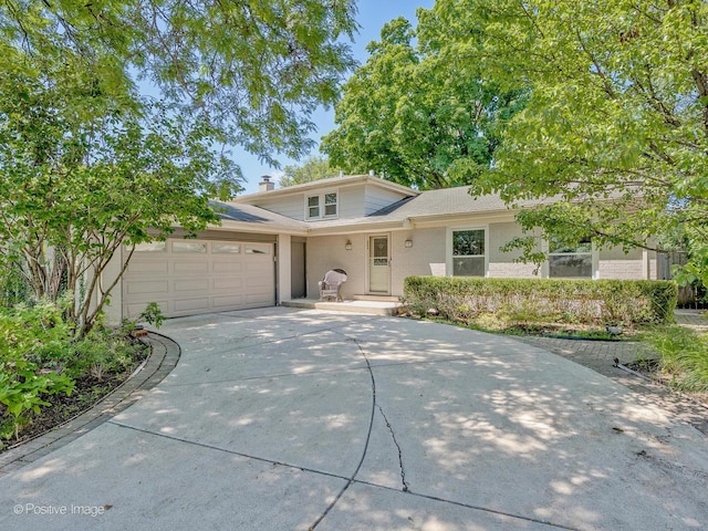 2246 Strawberry Ln, Glenview, IL 60026 - view of front facade with a garage, concrete driveway, brick siding, and a chimney