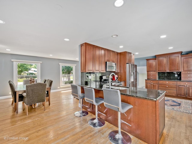 2246 Strawberry Ln, Glenview, IL 60026 - kitchen featuring stainless steel fridge, backsplash, light wood-style floors, a breakfast bar, and recessed lighting