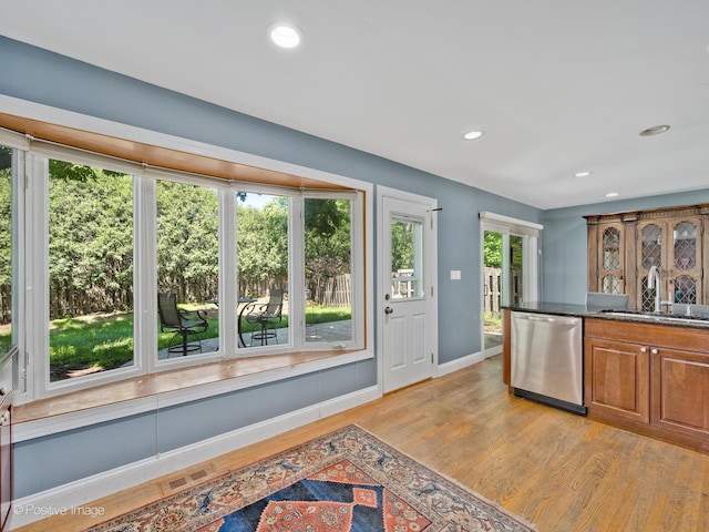 2246 Strawberry Ln, Glenview, IL 60026 - kitchen with stainless steel dishwasher, brown cabinets, light wood-style flooring, recessed lighting, and dark stone counters