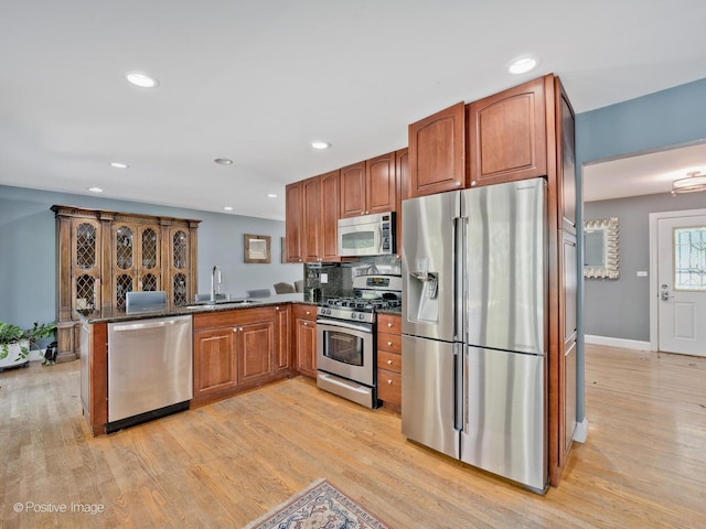 2246 Strawberry Ln, Glenview, IL 60026 - kitchen featuring appliances with stainless steel finishes, a peninsula, light wood-style flooring, brown cabinets, and recessed lighting