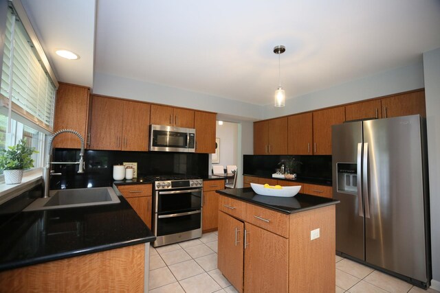 1061 Franklin St, Mundelein, IL 60060 - kitchen with stainless steel appliances, dark countertops, light tile patterned flooring, brown cabinets, and a kitchen island