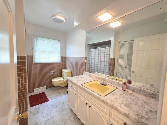 727 N Fordham Ave, Aurora, IL 60506 - full bathroom featuring tile walls, vanity, marble finish floors, and a wainscoted wall