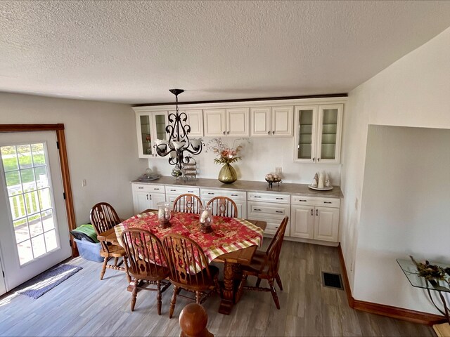 1116 E 2300 N Rd, Danforth, IL 60930 - dining space with light wood-style flooring, a chandelier, and a textured ceiling