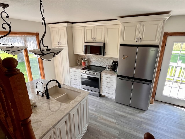 1116 E 2300 N Rd, Danforth, IL 60930 - kitchen with stainless steel appliances, decorative backsplash, light wood-style floors, white cabinetry, and light stone counters