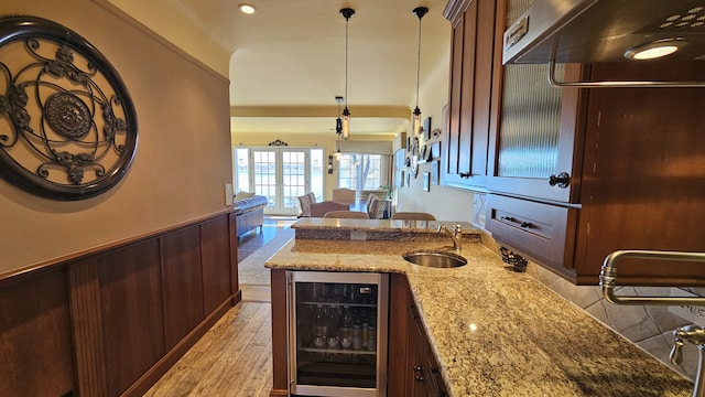 40752 N Grand Ave, Antioch, IL 60002 - kitchen with wine cooler, light stone counters, open floor plan, a wainscoted wall, and hanging light fixtures