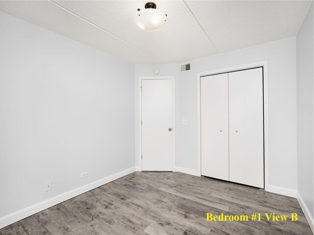 8540 W Foster Ave Unit 403, Norridge, IL 60706 - unfurnished bedroom with wood finished floors, a closet, and a textured ceiling