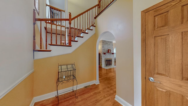 3354 N Overhill Ave, Chicago, IL 60634 - stairs with arched walkways, wood finished floors, a brick fireplace, and a high ceiling