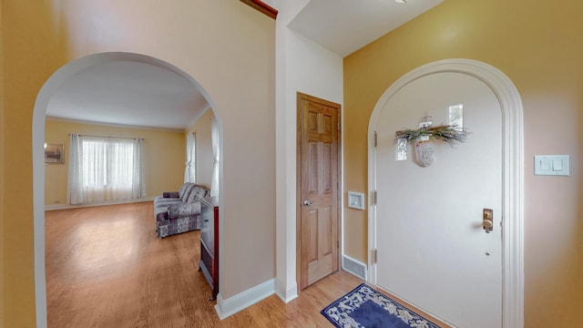 3354 N Overhill Ave, Chicago, IL 60634 - entrance foyer with arched walkways, light wood finished floors, and ornamental molding