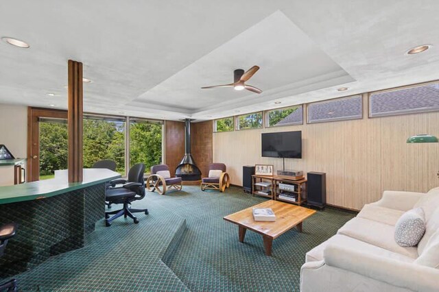 7370 Forest Hill Rd, Burr Ridge, IL 60527 - carpeted living room with a raised ceiling, a ceiling fan, wooden walls, recessed lighting, and floor to ceiling windows