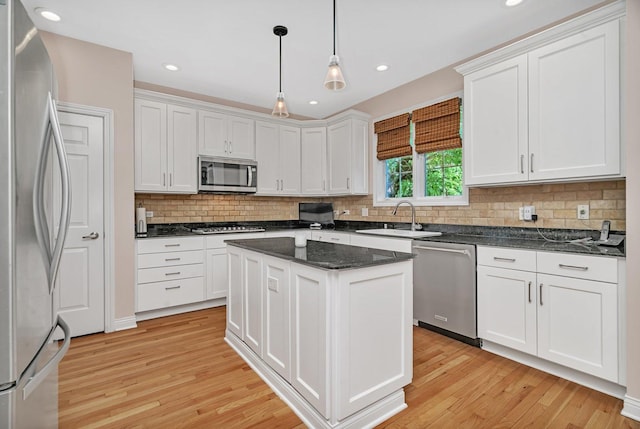 2319 Hutchison Rd, Flossmoor, IL 60422 - kitchen with appliances with stainless steel finishes, light wood-style floors, white cabinetry, decorative backsplash, and decorative light fixtures