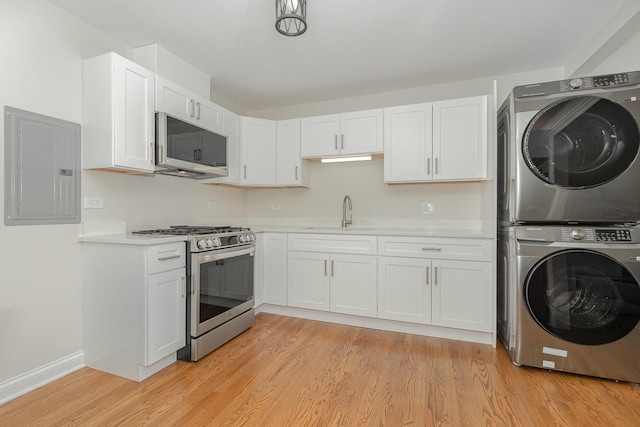 8954 Southfield Dr, Bridgeview, IL 60455 - kitchen featuring appliances with stainless steel finishes, stacked washer and clothes dryer, electric panel, light countertops, and white cabinetry