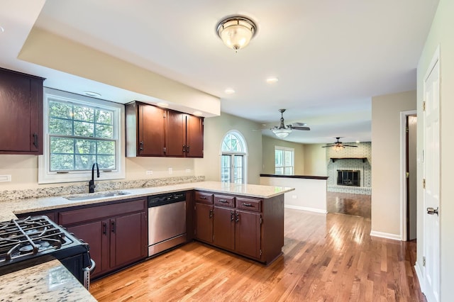 918 Carol Ln, Crete, IL 60417 - kitchen featuring dishwasher, light wood-style floors, a brick fireplace, a ceiling fan, and a peninsula
