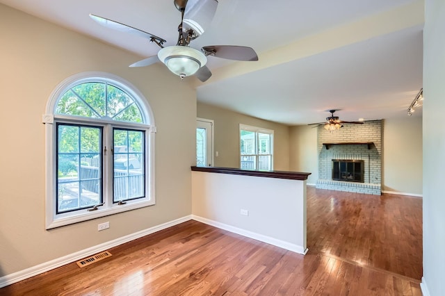 918 Carol Ln, Crete, IL 60417 - unfurnished living room featuring a ceiling fan, wood finished floors, and a brick fireplace
