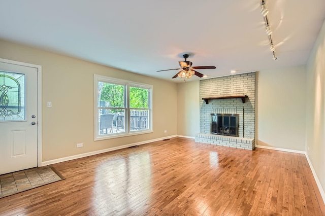 918 Carol Ln, Crete, IL 60417 - unfurnished living room featuring hardwood / wood-style floors, ceiling fan, track lighting, and a brick fireplace
