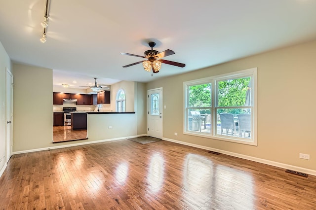 918 Carol Ln, Crete, IL 60417 - unfurnished living room with ceiling fan, rail lighting, and wood finished floors